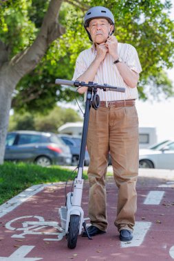 Şehir parkında elektrikli scooter kullanan son sınıf öğrencisi.