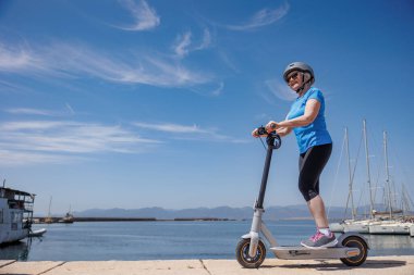 Güneşli bir günde scooterlı bir kadın