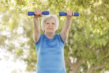 kadın dumbbell ile egzersiz yaparak