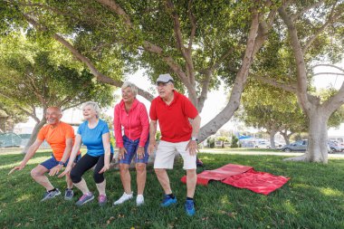 group of senior people exercising in park  clipart