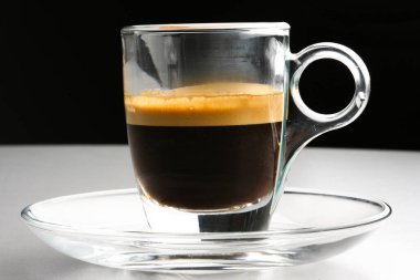 Siyah arka planda bir bardak espresso kahvesi. 