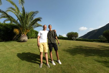 Baba ve oğul yeşil çimlerin üzerinde öylesine duruyorlar.