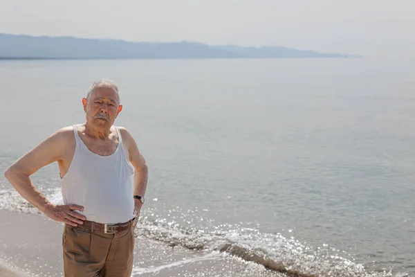 Deniz Kenarında Askılı Tişört Giymiş Yaşlı Bir Beyefendi Ciddi Bir — Stok fotoğraf