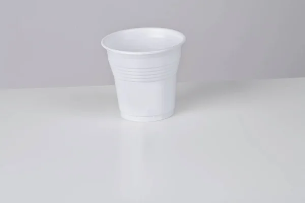白い背景に空の白いプラスチックカップ コピースペース — ストック写真