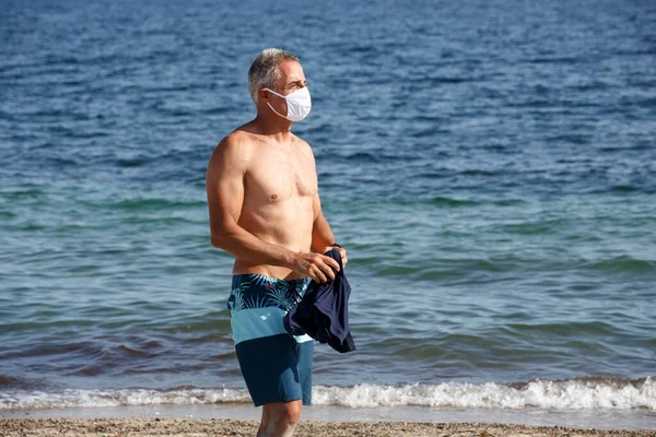 Летний Мужчина Рубашки Стоит Пляже Купальнике Снимает Защитную Маску — стоковое фото