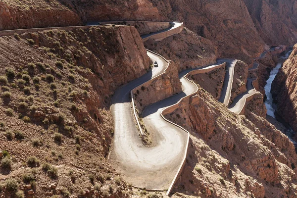 stock image Curving serpentine winding road in Dades Gorge mountain canyon. Famous touristic landmark of Morocco, R704 Way. Aerial view.