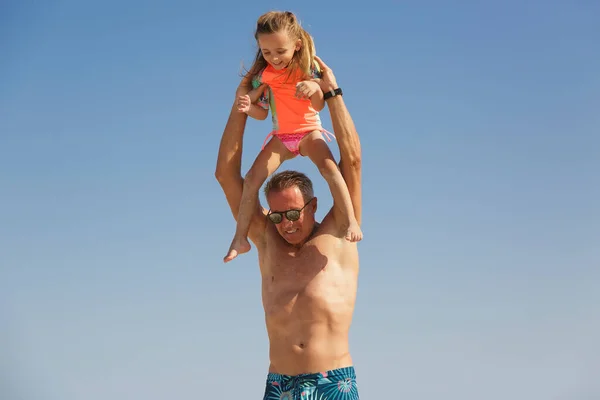 一位父亲把女儿抱在肩上 在海边和她好好地玩耍 — 图库照片