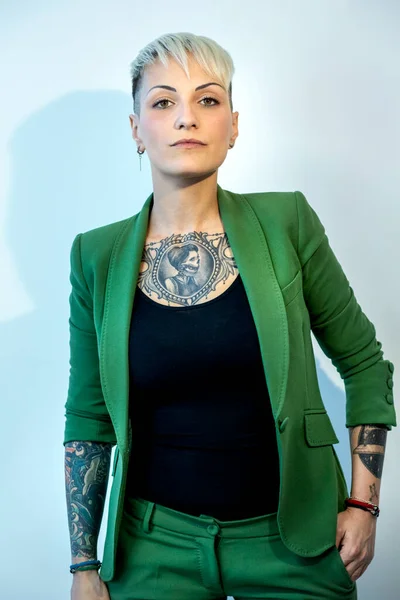 stock image Tattooed girl dressed in green jacket isolated on light background