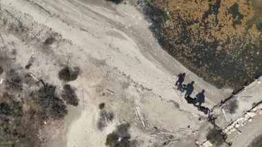 Gölet ve üç durağan adam yukarıdan bir dron tarafından alındı. 