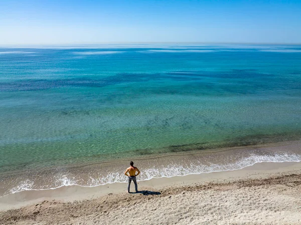 해변을 공중에서 내려다본 바다를 바라보고 외로운 남자가 보인다 — 스톡 사진