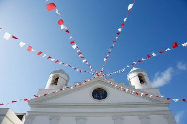 Kilisenin düşük açılı görüntüsü ve mavi gökyüzüne karşı renkli bayraklar