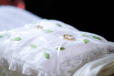 Beyaz bir yastıkta alyansın yakın plan fotoğrafı. 