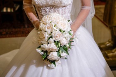 Gelin bir buket gül tutuyor. 