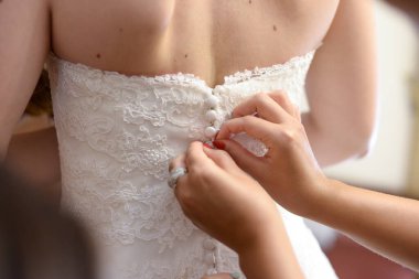 Gelin gelinliği giyiyor.