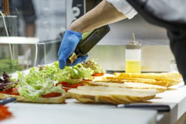 Şef cam kaseye bıçakla salata koyuyor. 