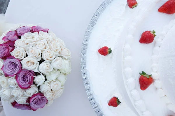wedding cake with white roses and strawberries