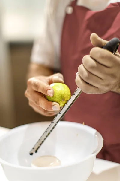 Koch Reibt Eine Zitrone Der Küche — Stockfoto