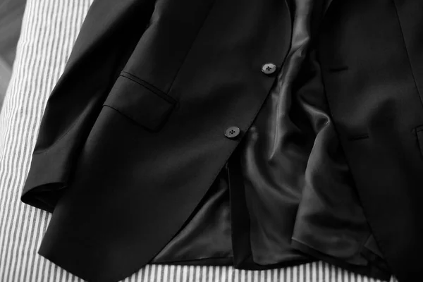 Çizgili Bir Yatağın Üzerinde Siyah Adam Kıyafeti Ayrıntıları — Stok fotoğraf