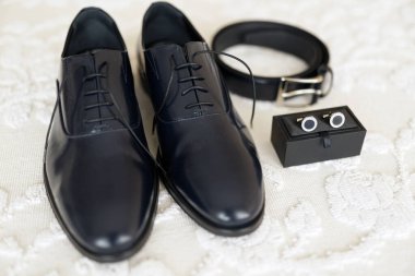 Beyaz ahşap arka planda şık erkek aksesuarları. Erkek ayakkabıları, aksesuarlar, siyah beyaz ayakkabılar. en üstteki görünüm 