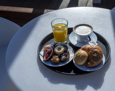 Bir kafede bir fincan kahve ve kruvasanla kahvaltı. 