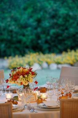 Bir restorandaki ziyafet masasında çiçekli bir masa. 