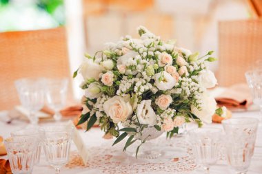 Düğün salonundaki masada beyaz ve pembe çiçeklerle güzel bir buket. 