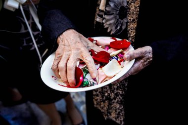 Kadın düğün günü taçyapraklı bir tabak tutuyor.