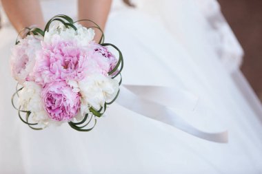 Gelinin ellerinde bir buket çiçek.