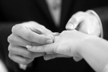 Gelin parmağına alyans takan bir erkeğin yakın çekimi.  
