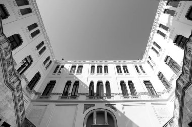 Şehirdeki eski bir binanın siyah beyaz fotoğrafı. 