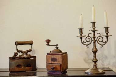 Beyaz bir masada antika bir şamdan. 