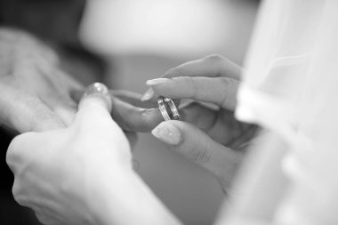 Gelin damadın parmağına alyans takar, siyah ve beyaz. 