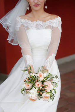 Gelin elinde bir buket tutuyor.