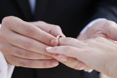 Gelin ve damat el ele tutuşuyor, alyanslar 