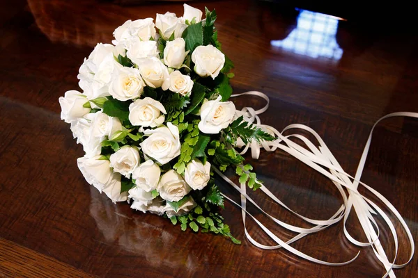 bouquet of white flowers with a ribbon on a black background