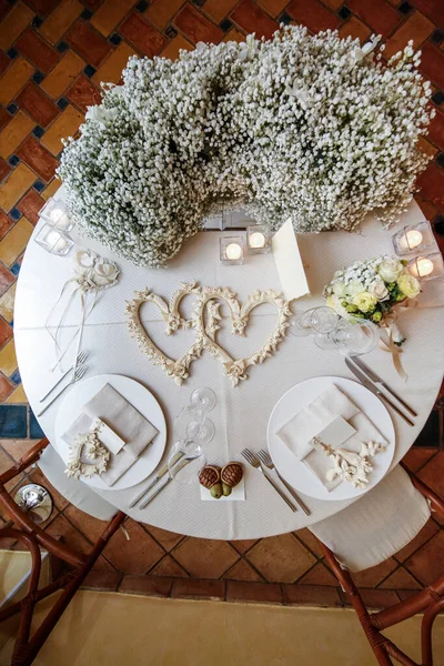 白いテーブルクロスに花の花束とワインのガラスとテーブルの設定 — ストック写真