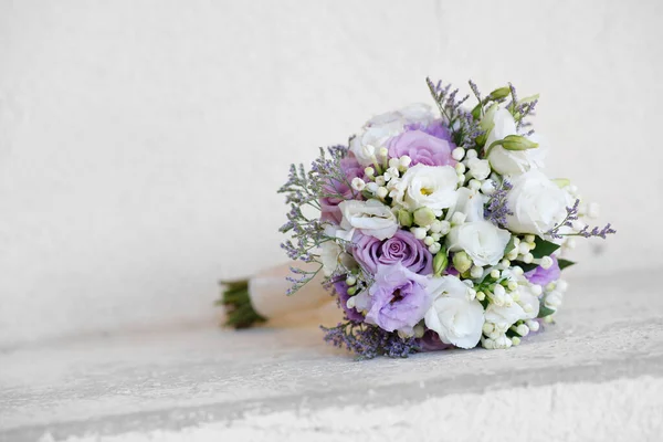 bouquet of purple flowers with a wedding rings on a white background