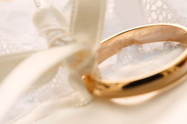 白色丝织品上的结婚戒指 — 图库照片