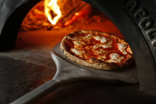 Stock image a vertical shot of a piece of pizza on a stove 