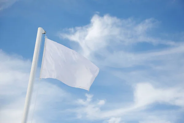 Valkoinen Lippu Heiluttaa Tuulessa Sinistä Taivasta Vasten Lähikuva — kuvapankkivalokuva