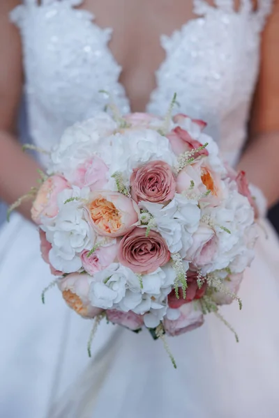 新娘手中拿着玫瑰和新娘的婚礼花束 — 图库照片
