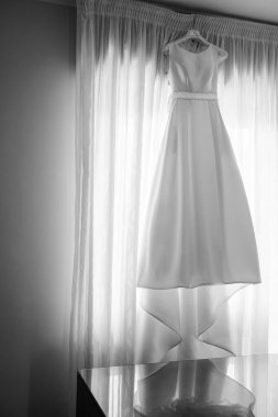 Penceresinde askı olan beyaz elbise 