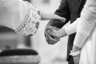 Gelin ve damat el ele tutuşuyorlar, siyah ve beyaz. 