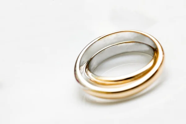 金色的结婚戒指躺在白色的表面上 结婚的概念 — 图库照片