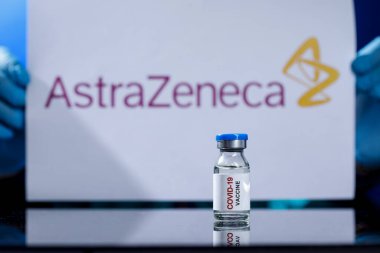 Bir laboratuvar masasının yansıtıcı yüzeyine yerleştirilmiş anti-covid aşısı.