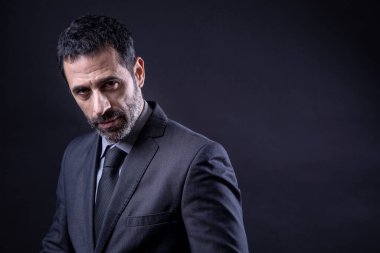 Siyah arkaplanda takım elbiseli ve kravatlı yönetici portresi