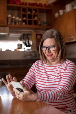 Evinde rahat olan yaşlı bir kadının portresi.