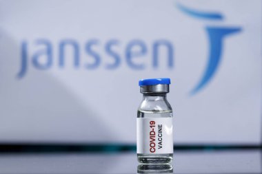 Bir laboratuvar masasının yansıtıcı yüzeyine yerleştirilmiş anti-covid aşısı.