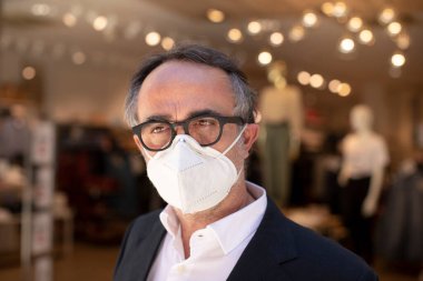 Koruyucu maske takan kıdemli işadamı