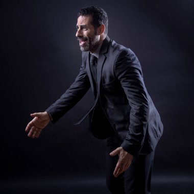 Zarif takım elbiseli yönetici siyah arkaplanda çabucak izole edilir